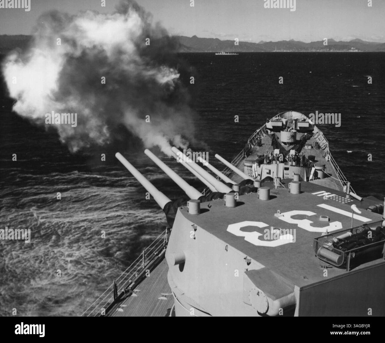 Commander Naval Forces, Far East Photographic Laboratory. Big 'T' Blasts wonsan - der rote Seehafen von Wonsan, Nordkorea, schaukelte unter dem Angriff der Bootstierartillerie, als der schwere Kreuzer USS Toledo sich mit Marine- und Lufteinheiten des Transportation Center zusammenschanzte. In der Ferne befindet sich einer der Zerstörer, der der Operation nahe an Land Unterstützung gibt. 26. September 1951. (Foto von einem offiziellen US-Navy-Foto). Stockfoto