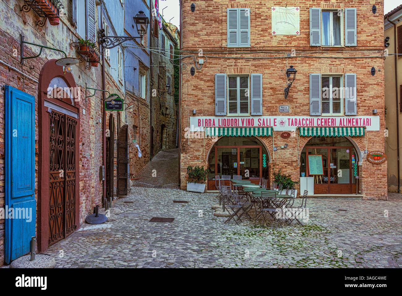 Farbenfrohe Häuser und Terrakotta-Backsteingebäude umgeben die Piazza Peretti in der Altstadt von Grottammare. Ascoli Piceno, Marken, Italien, Europa Stockfoto