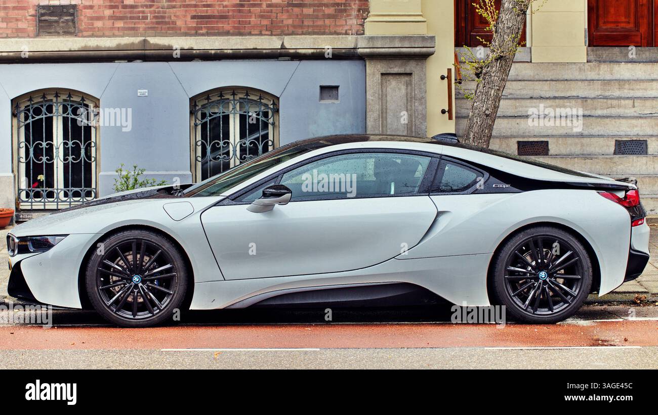 Ein weißer BMW i8 parkt entlang einer Straße in Amsterdam, Niederlande, und präsentiert eine Mischung aus modernstem Automobildesign und klassischer Architektur der Stadt Stockfoto