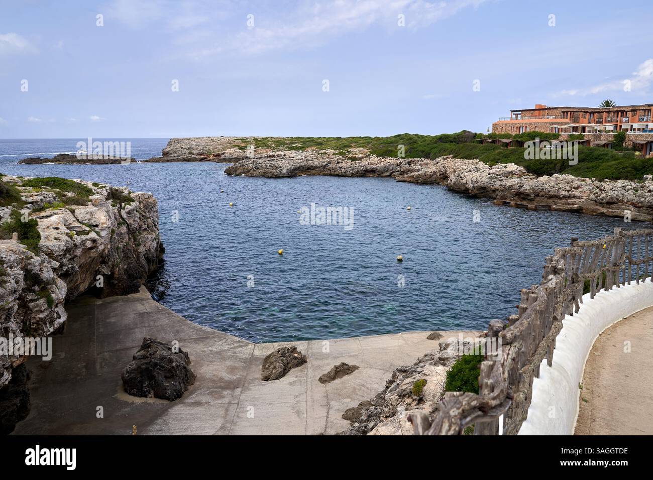 Eine malerische Aussicht auf Binibeca, Menorca, mit Blick auf die felsige Küste und das ruhige Meer unter klarem Himmel. Das Foto zeigt eine ruhige und malerische Küste Stockfoto