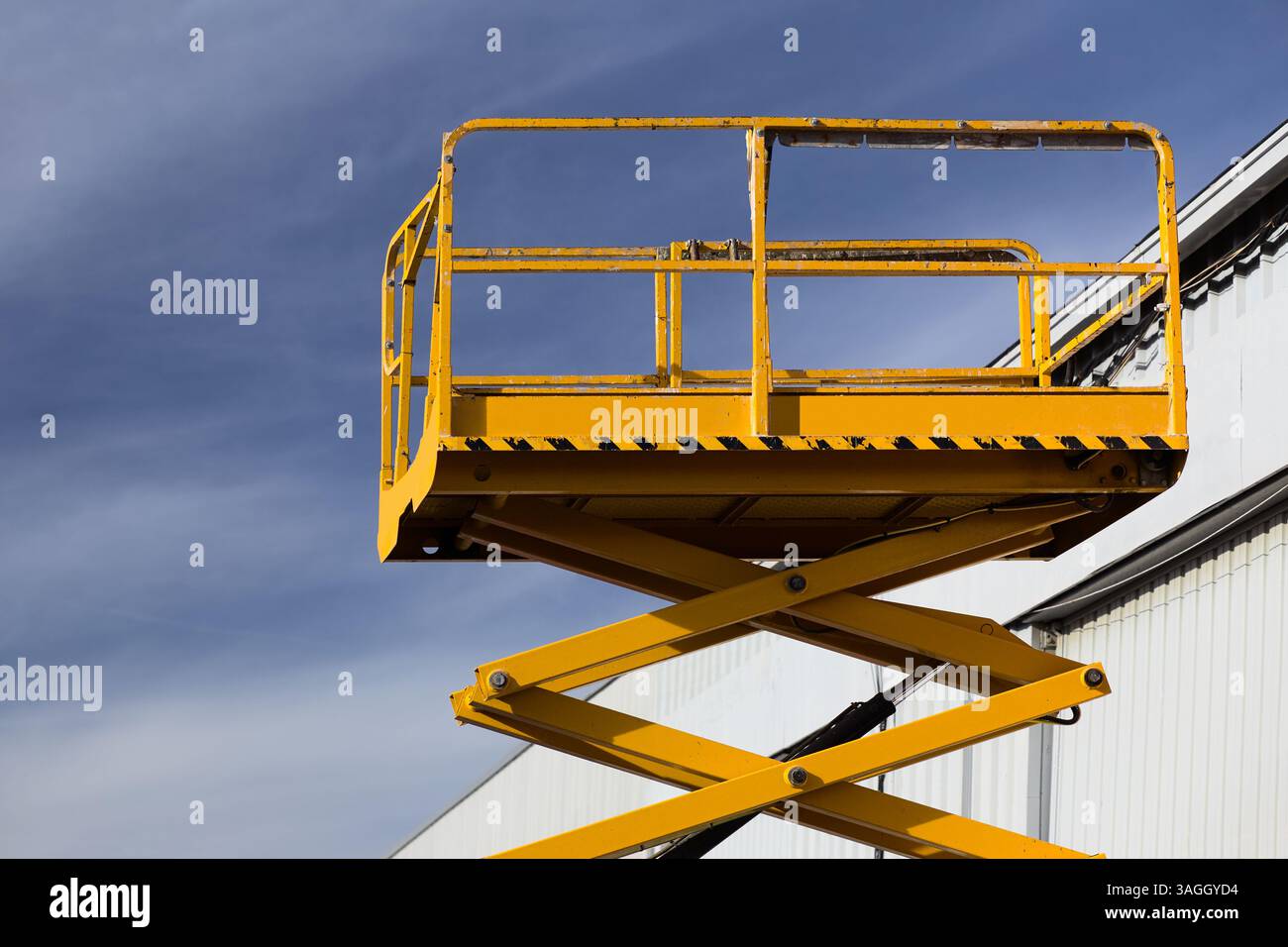 Hydraulische Scherenarbeitsbühne man Heber vor dem Gebäude zur Wartung Stockfoto