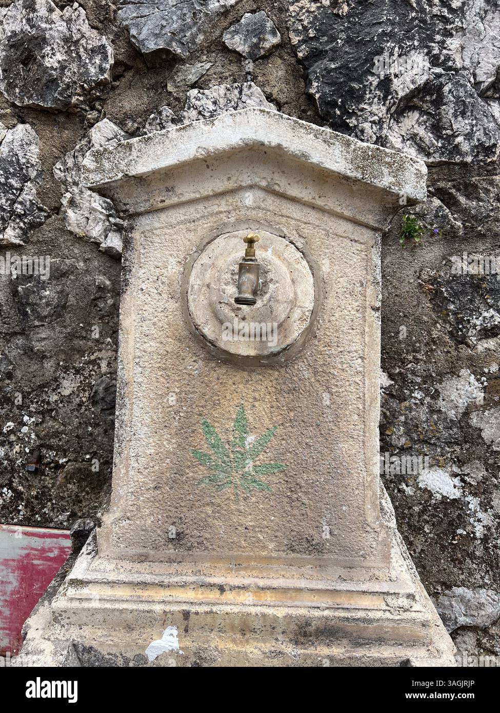 Greolieres, Frankreich - 09-07-2022: Wasserbrunnen in einem kleinen Dorf mit Cannabis-Graffiti - Smartphone-aufgenommenes Stockfoto