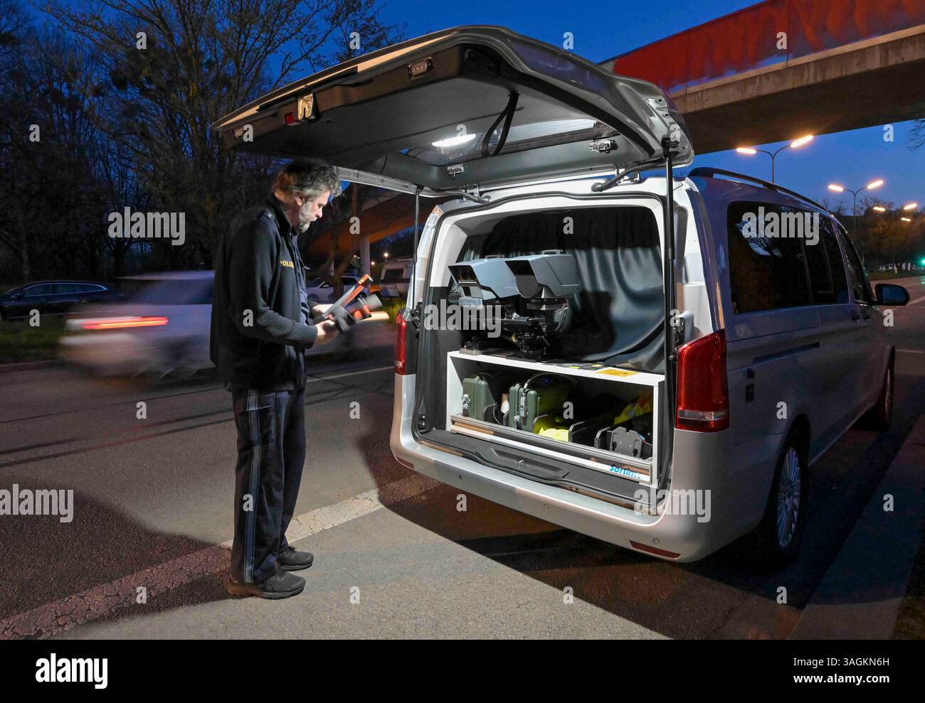 München, Deutschland. April 2025. Ein Polizist baut sein Radarsystem Poliscan FM1 in den frühen Morgenstunden für den Radarmarathon in Bayern auf. Ab 6,00 Uhr überwacht die Polizei die Straßengeschwindigkeit an rund 1.500 Kontrollpunkten in ganz Bayern 24 Stunden lang. Quelle: Peter Kneffel/dpa/Alamy Live News Stockfoto