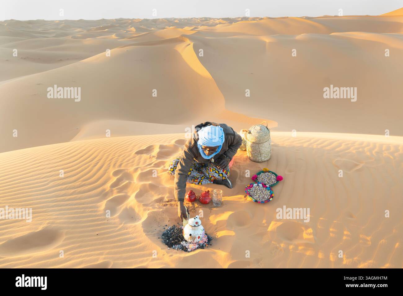 Tuareg-Mann bereitet Tee am Lagerfeuer in der algerischen sahara vor Stockfoto