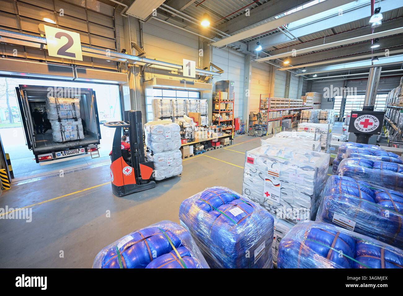 Berlin, Deutschland. April 2025. Hilfsgüter für die Erdbebenopfer in Myanmar werden von Mitarbeitern des Deutschen Roten Kreuzes (DRK) im DRK Logistikzentrum am Flughafen Schönefeld geladen. Insgesamt sollen 42 Tonnen Hilfsgüter in das von einem schweren Erdbeben betroffene Land gebracht werden. Quelle: Sebastian Christoph Gollnow/dpa/Alamy Live News Stockfoto