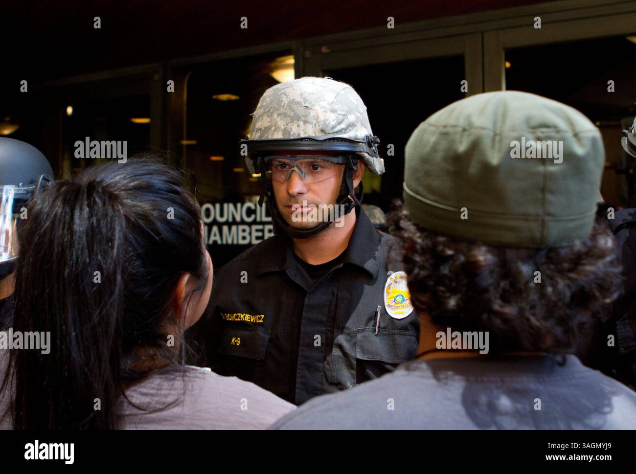 24. Juli 2012 - Anaheim, Kalifornien, USA - ein Polizeibeamter aus Anaheim bewacht die Ratskammern am Dienstag Nachmittag während eines Protests in der Großstadt gegen die von der Polizei betroffenen Erschießungen am Wochenende. Die Polizei wurde mit Aufruhr ausgerüstet und verteilte schließlich eine Menge wütender Demonstranten mit Gummigeschossen und Paintball-Kugeln während einer Straßenblockade später am Abend. Hunderte von Demonstranten versammelten sich am Dienstag, den 24. Juli 2012, im Rathaus von Anaheim, nachdem zwei umstrittene polizeibezogene Erschießungen zwei, 25-jährige Manuel Diaz und den 21-jährigen Joel Mathew Acevedo getötet hatten Stockfoto