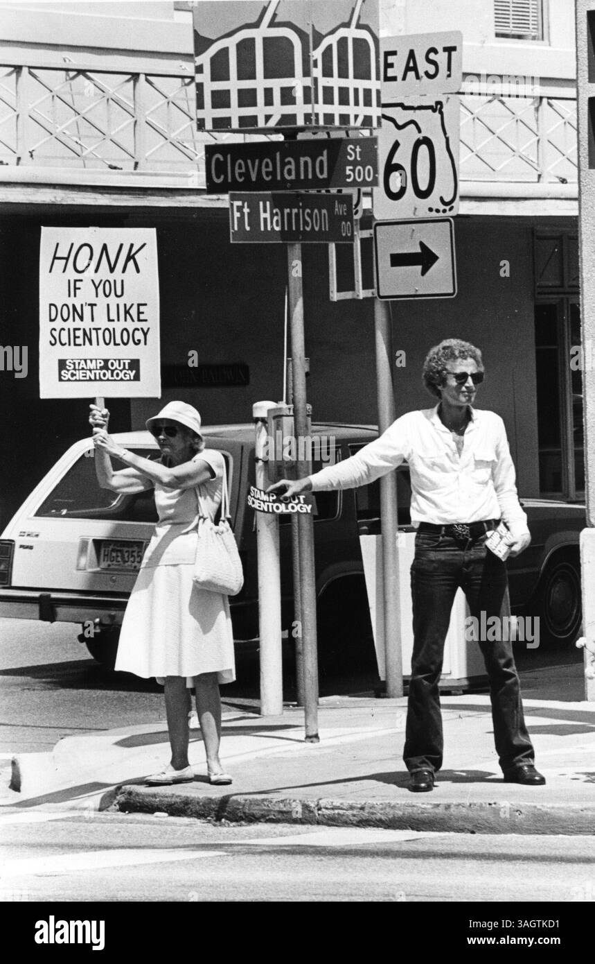 27. August 1980 - Clearwater, Florida, USA - ARIAN TENNEY (links), Mutter von Clearwater City Commissioner R. Tenney, fordert vorbeifahrenden Autofahrer dazu auf, während einer Demonstration gegen Scientology zu protestieren. Der Scientology-Feind ALEX CORNELL (rechts) sagte, er habe die kurze, laute Demonstration durchgeführt, um den vorbeifahrenden Scientologen wissen zu lassen, dass nicht jeder ihre Anwesenheit hier billigt. (Foto: © Dave Pierson/St Petersburg Times/ZUMA Press) EINSCHRÄNKUNGEN: * Tampa Tribune OUT * Stockfoto