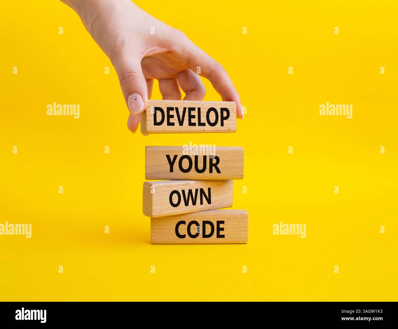 Entwickeln Sie Ihr eigenes Codesymbol. Concept Words entwickeln Ihren eigenen Code auf Holzblöcken. Schöner gelber Hintergrund. Geschäftsmann Hand. Business und Develo Stockfoto