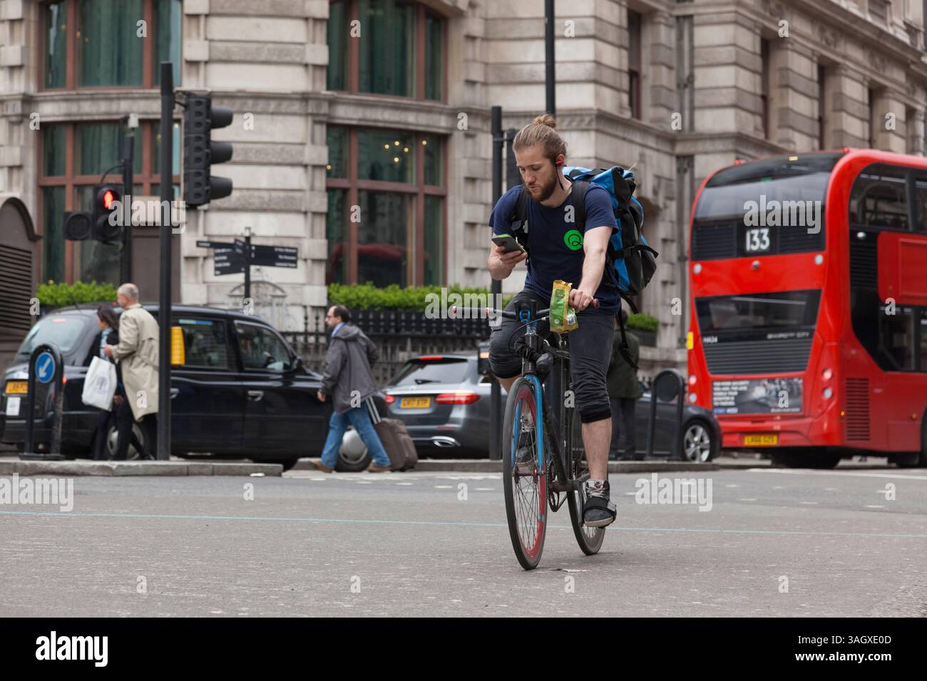 Radfahrer, der sein Handy ansieht, City of London Stockfoto