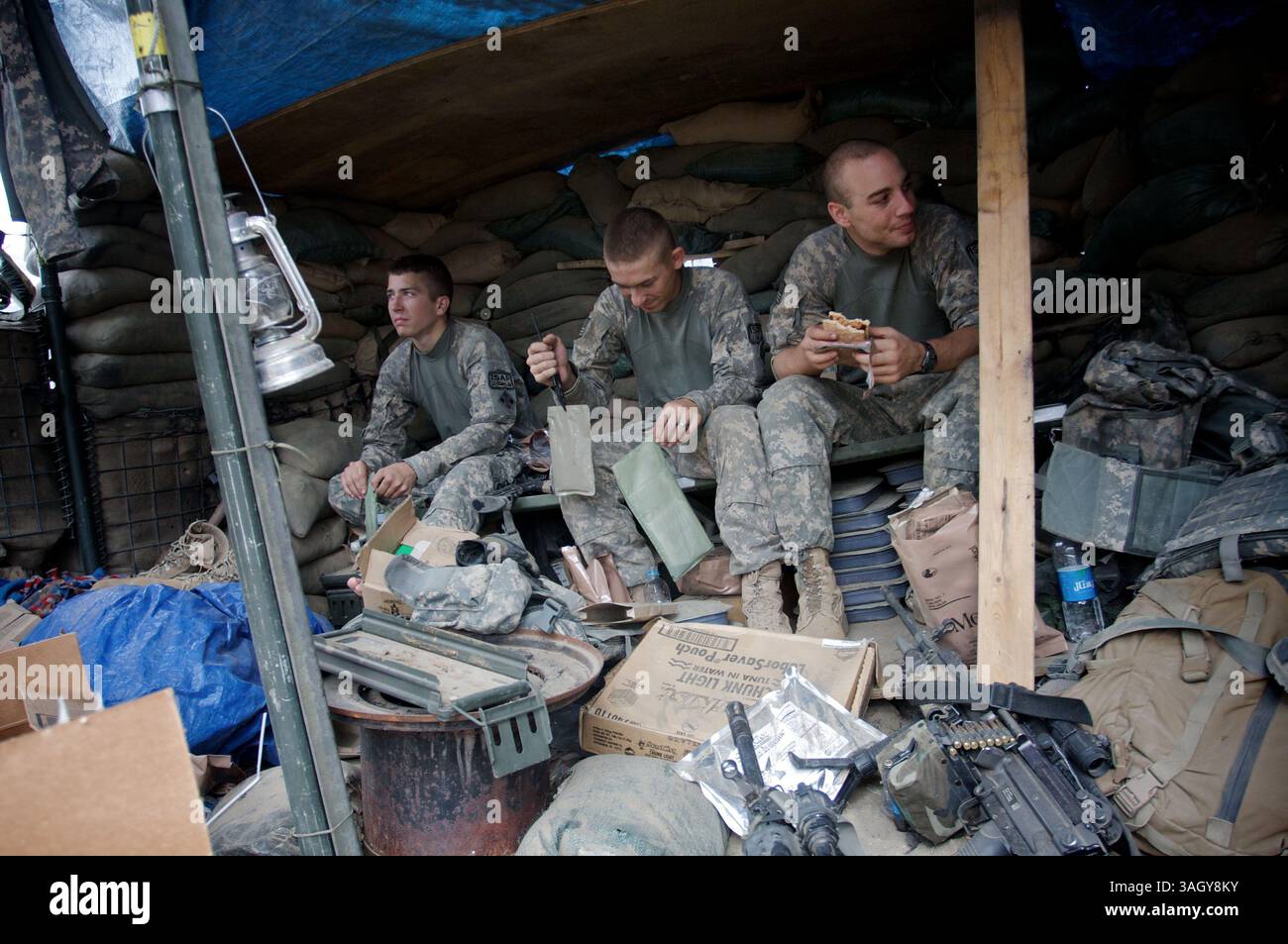 Juli 2009 - Nanghalam, Kunar, Afghanistan - (VON LINKS NACH RECHTS) PFC EGGERS, PFC BENTHAM, PFC CONELLY der US Army 2nd Platoon, Alpha Company, 2nd BN, 12th Infantry Regiment, 4th Brigade, 4. Infanterie-Division bei der Observation Post Avalanche bereiten Sie Instant-Mahlzeiten für das Mittagessen vor. (Kreditbild: © John Goodman/ZUMA Press) Stockfoto