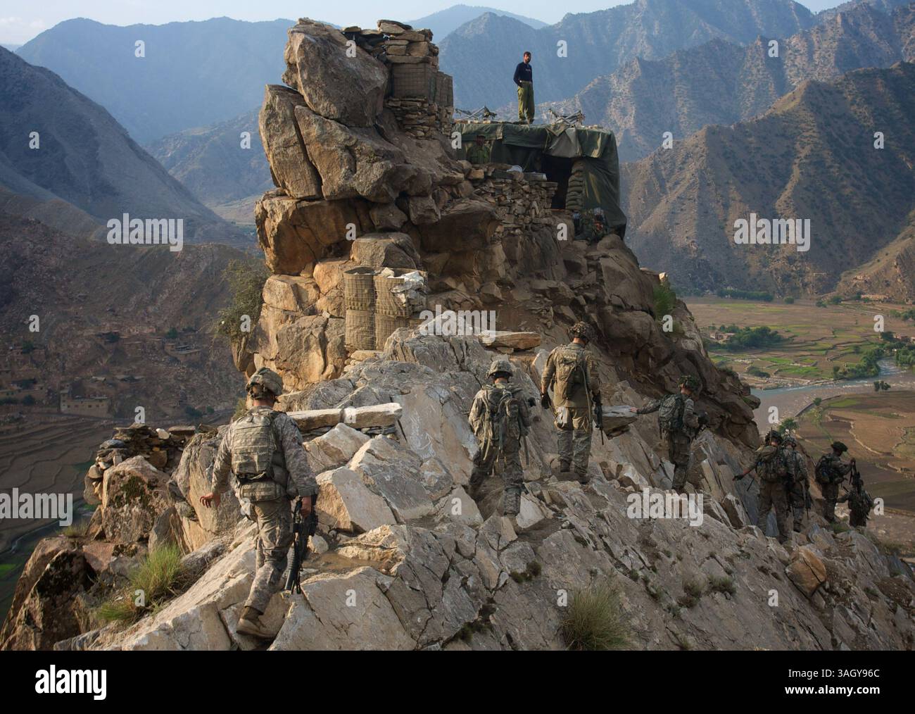Juli 2009 - Nanghalam, Kunar, Afghanistan - 2. Zug der US-Armee, Alpha-Kompanie, 2. BN, 12. Infanterieregiment, 4. Brigade, die 4. Infanterie-Division auf Patrouille kommt an einem Beobachtungsposten der afghanischen Nationalarmee über dem Pesh River Valley vorbei. (Kreditbild: © John Goodman/ZUMA Press) Stockfoto