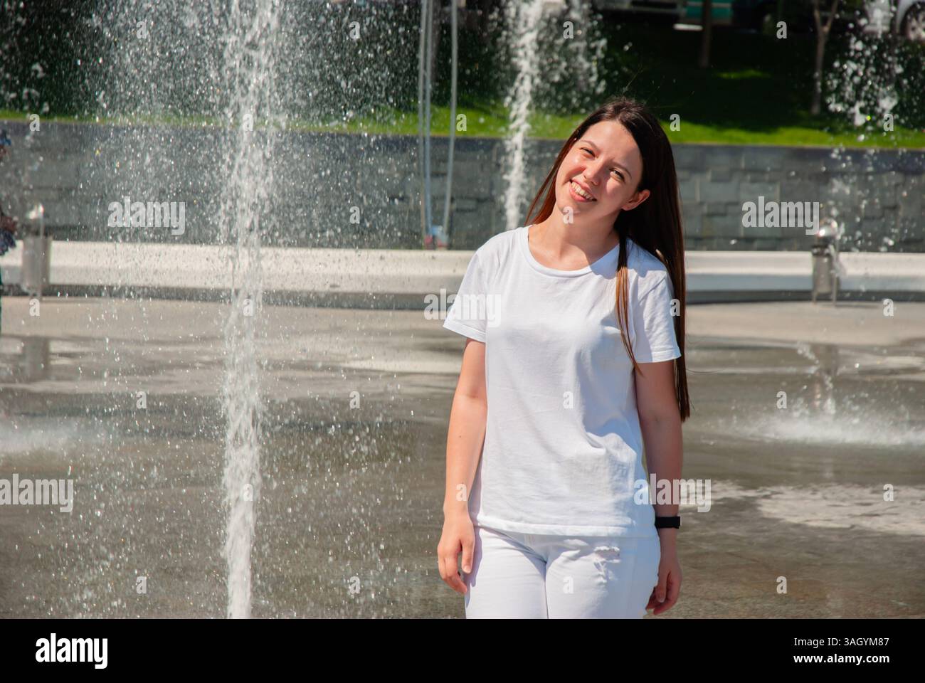 Fröhliche Frau, die einen sonnigen Tag am Brunnen genießt. Frohe Sommertage, Reise- und Urlaubskonzept. Stockfoto