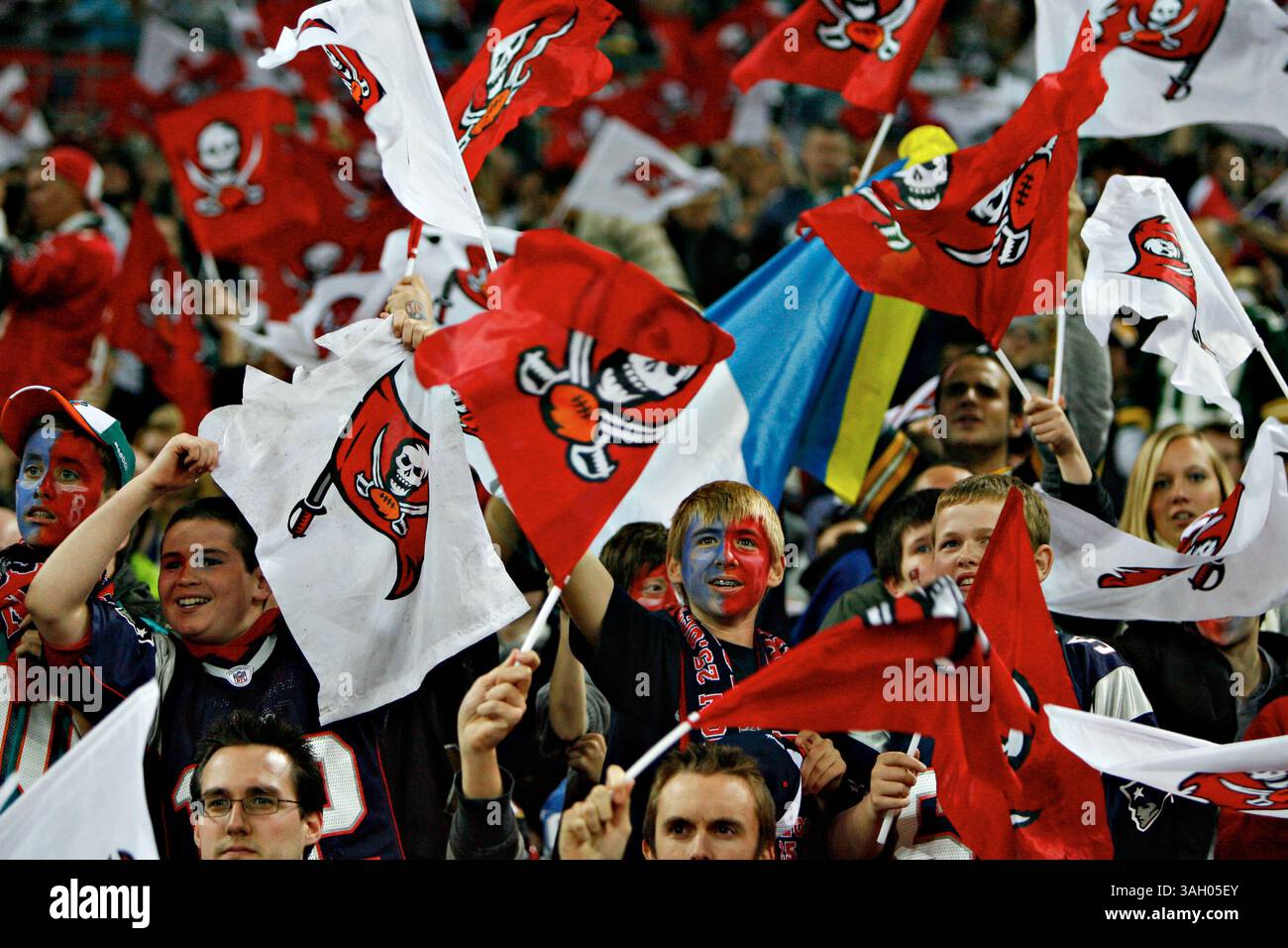 DANIEL WALLACE | Times. OT 313577 WALL Bucs 29 (10/25/2009 London) Matthew Shaw, Center und andere Klassenkameraden der Richard Challoner School in New Malden, England, schwenken im vierten Quartal Buccaneers-Flaggen. Die Tampa Bay Buccaneers spielen die New England Patriots im Wembley Stadium in London. [DANIEL WALLACE, Times] (Foto: © St. Petersburg Times/ZUMA Press) Stockfoto