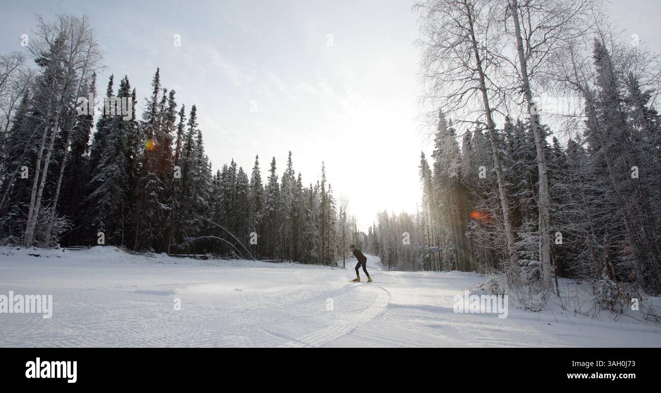 Eric Engman/News-Miner. Ein Skateboarder überquert eine Kreuzung der Piste, während die Skifahrer in die Birch Hill Recreation Area strömen, um den Neuschnee zu nutzen, um am Mittwoch Nachmittag, den 28. Oktober 2009, Ski zu fahren. Die Pistenfahrer haben das gesamte Trailsystem, das bisher etwa 1,6 cm Schnee hat, gepackt und gerollt. Weitere wenige Zentimeter sind jedoch nötig, bevor klassische Skipisten eingestellt werden können. (Kreditbild: © Fairbanks Daily News-Miner/ZUMAPRESS.com) Stockfoto