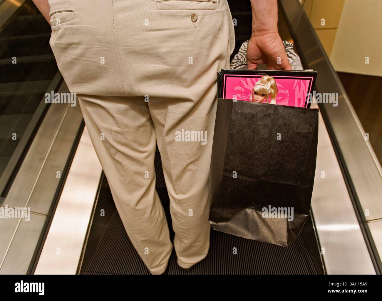 10. Juli 2009 - Washington, District of Columbia, USA - Eine Barbie blickt aus der Einkaufstasche eines Kongressteilnehmers auf der Barbie Barbie Doll Collectors Convention. Etwa 1.200 Barbie-Fans aus aller Welt trafen sich in der US-Hauptstadt, um das 50. Jubiläum der berühmtesten Puppe der Welt zu feiern und sich an vier Tagen von Barbie inspirierten Veranstaltungen zu erfreuen. Es wird geschätzt, dass in den letzten 50 Jahren mehr als eine Milliarde Barbies verkauft wurden und dass 90 % der amerikanischen Mädchen mindestens eine Barbie-Puppe haben. (Kreditbild: © Brian Cahn/ZUMA Press) Stockfoto