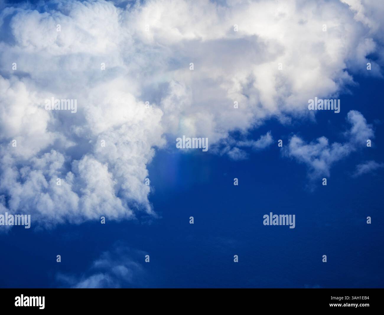 Ein Flugzeug, das nach dem Start vom Flughafen Manchester, Großbritannien, mit einer Regenboe über Wolken fliegt. Stockfoto