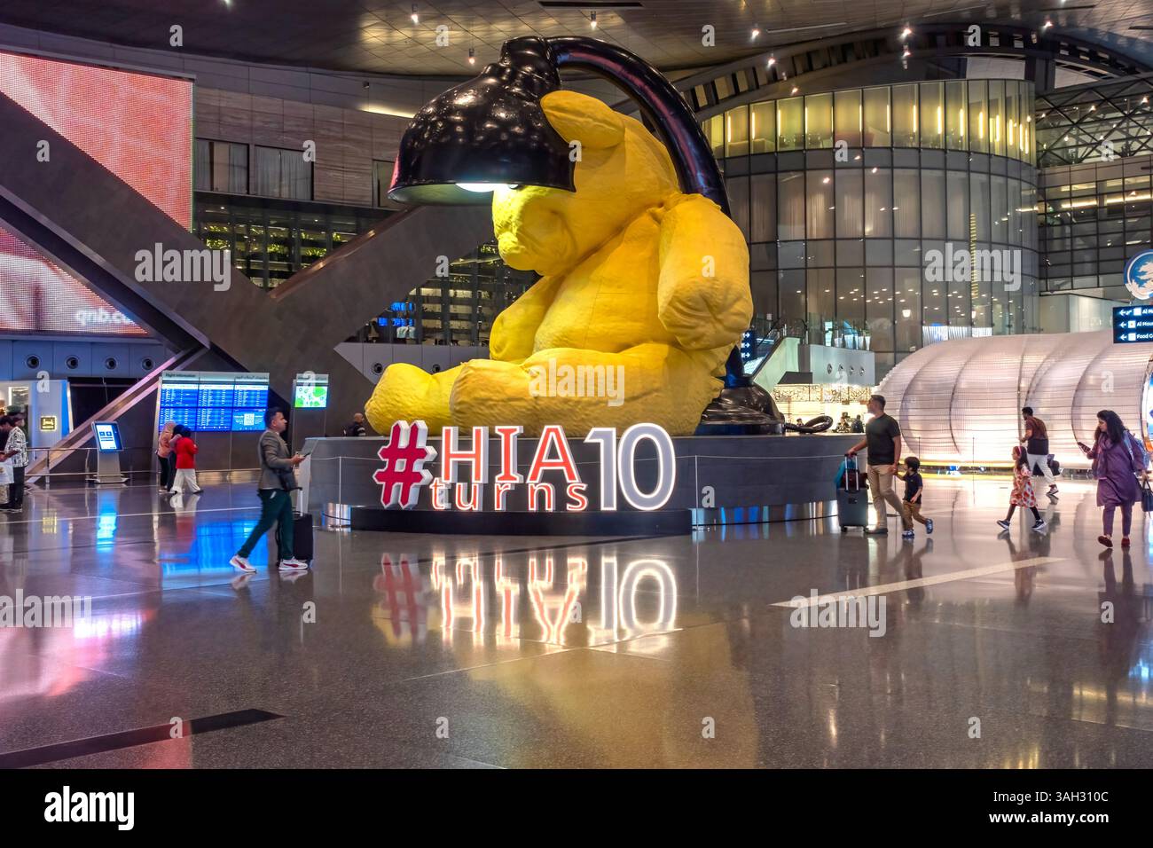 Ein fesselnder Blick bei Nacht auf den internationalen Flughafen Hamad mit seiner modernen Architektur, beleuchtet mit lebendigem Licht Stockfoto