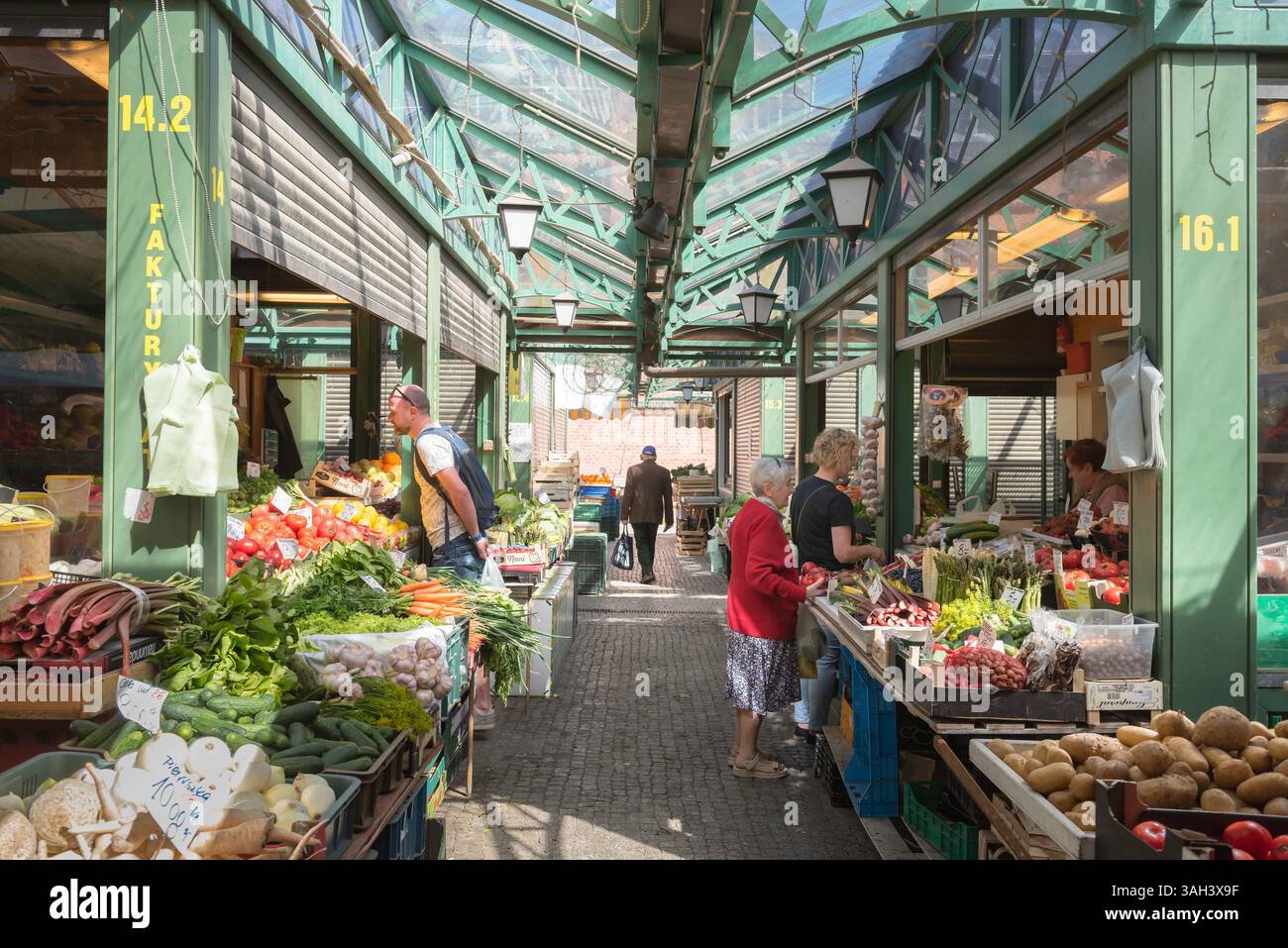 Einkaufsmöglichkeiten auf dem Lebensmittelmarkt, Blick auf die Menschen, die frisches Gemüse kaufen, in der Markthalle Hala Targowa in der historischen Altstadt von Danzig, Polen Stockfoto