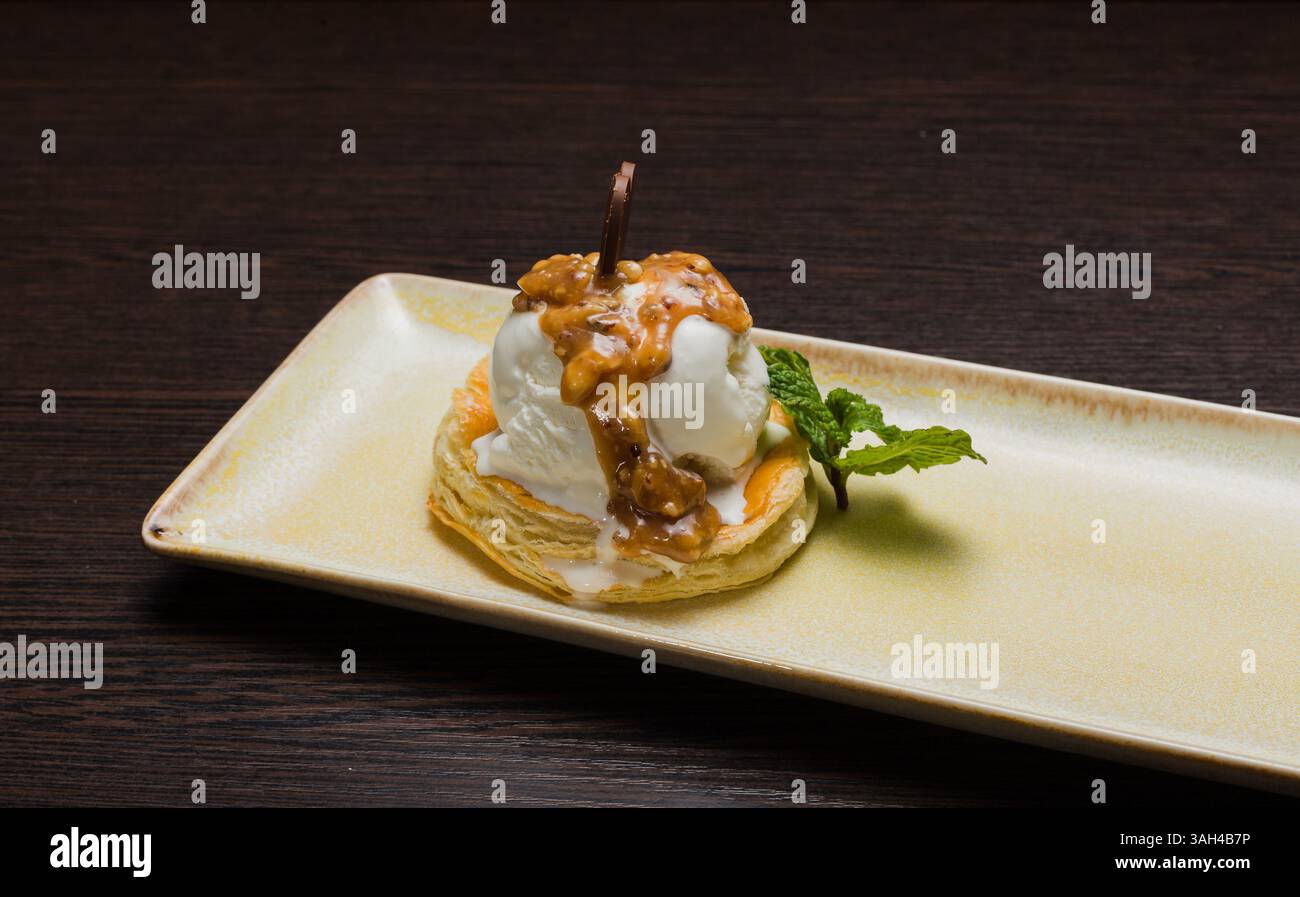 Dessert mit Blätterteig und Eis mit Karamell auf einem Teller Stockfoto