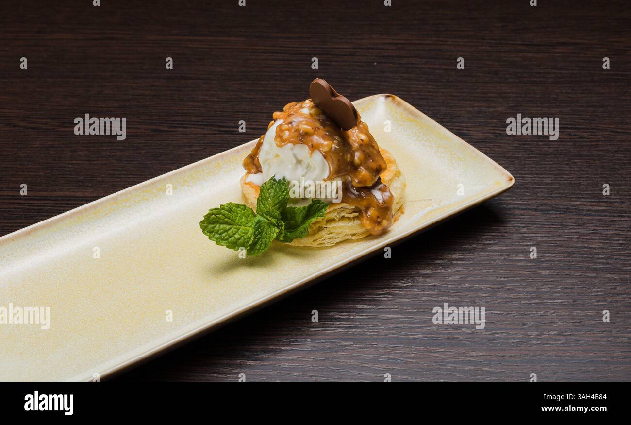 Dessert mit Blätterteig und Eis mit Karamell auf einem Teller Stockfoto