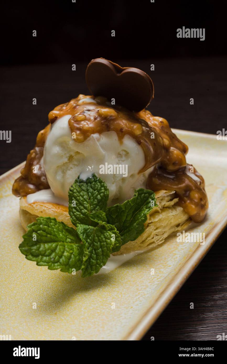 Dessert mit Blätterteig und Eis mit Karamell auf einem Teller Stockfoto