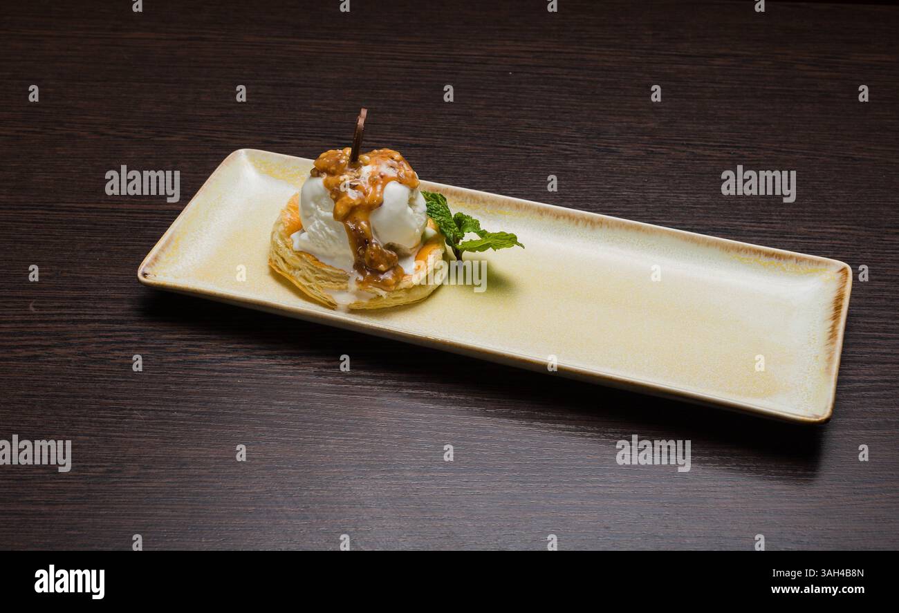 Dessert mit Blätterteig und Eis mit Karamell auf einem Teller Stockfoto