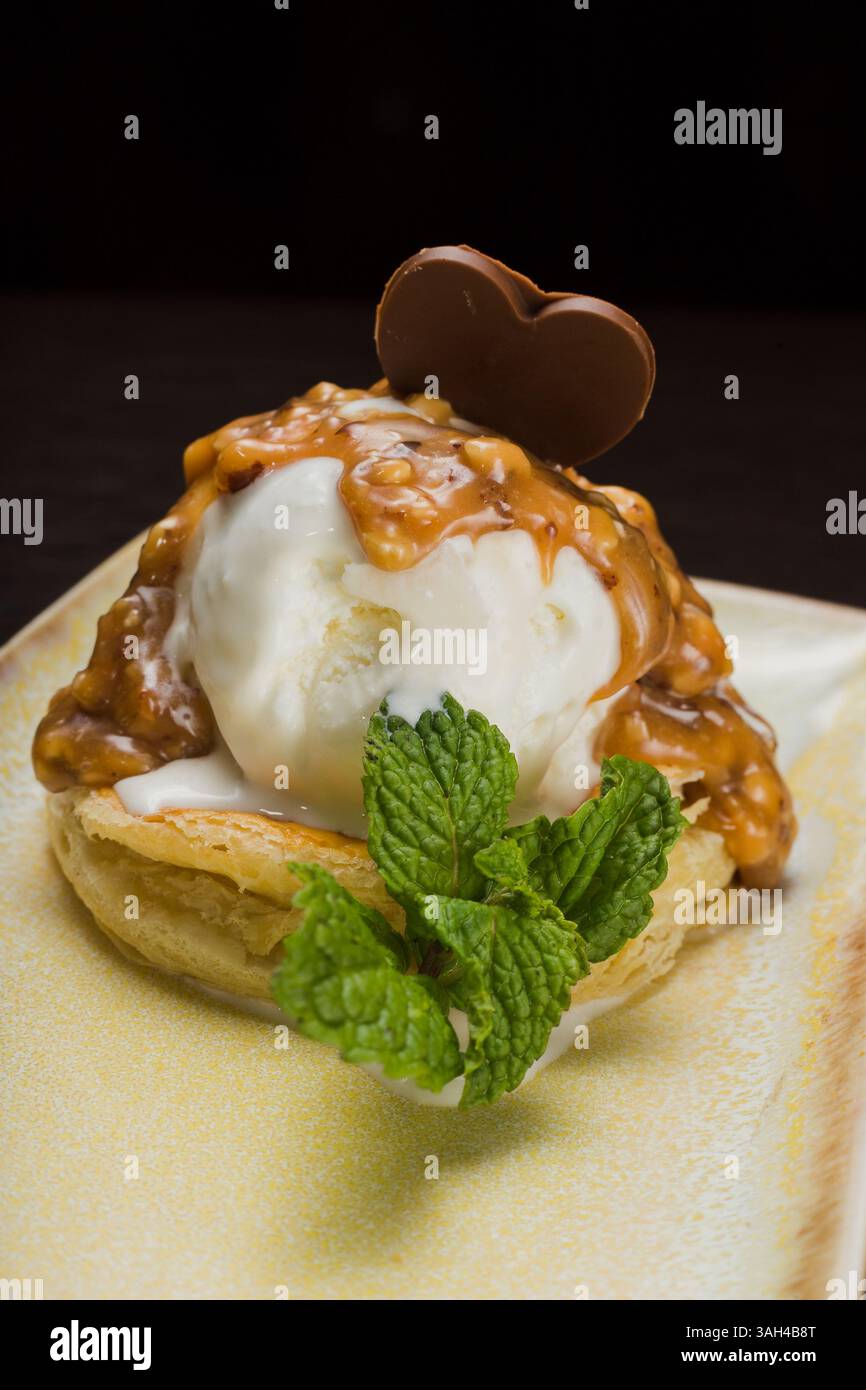 Dessert mit Blätterteig und Eis mit Karamell auf einem Teller Stockfoto