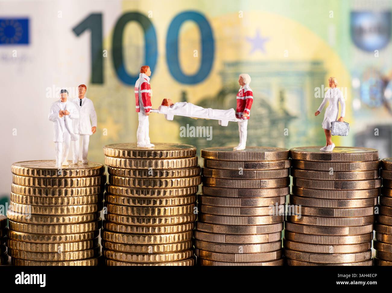 Symbolisches Foto mit Zahlen aus dem Gesundheitswesen auf Geldstapeln vor einem 100-Euro-Schein Stockfoto