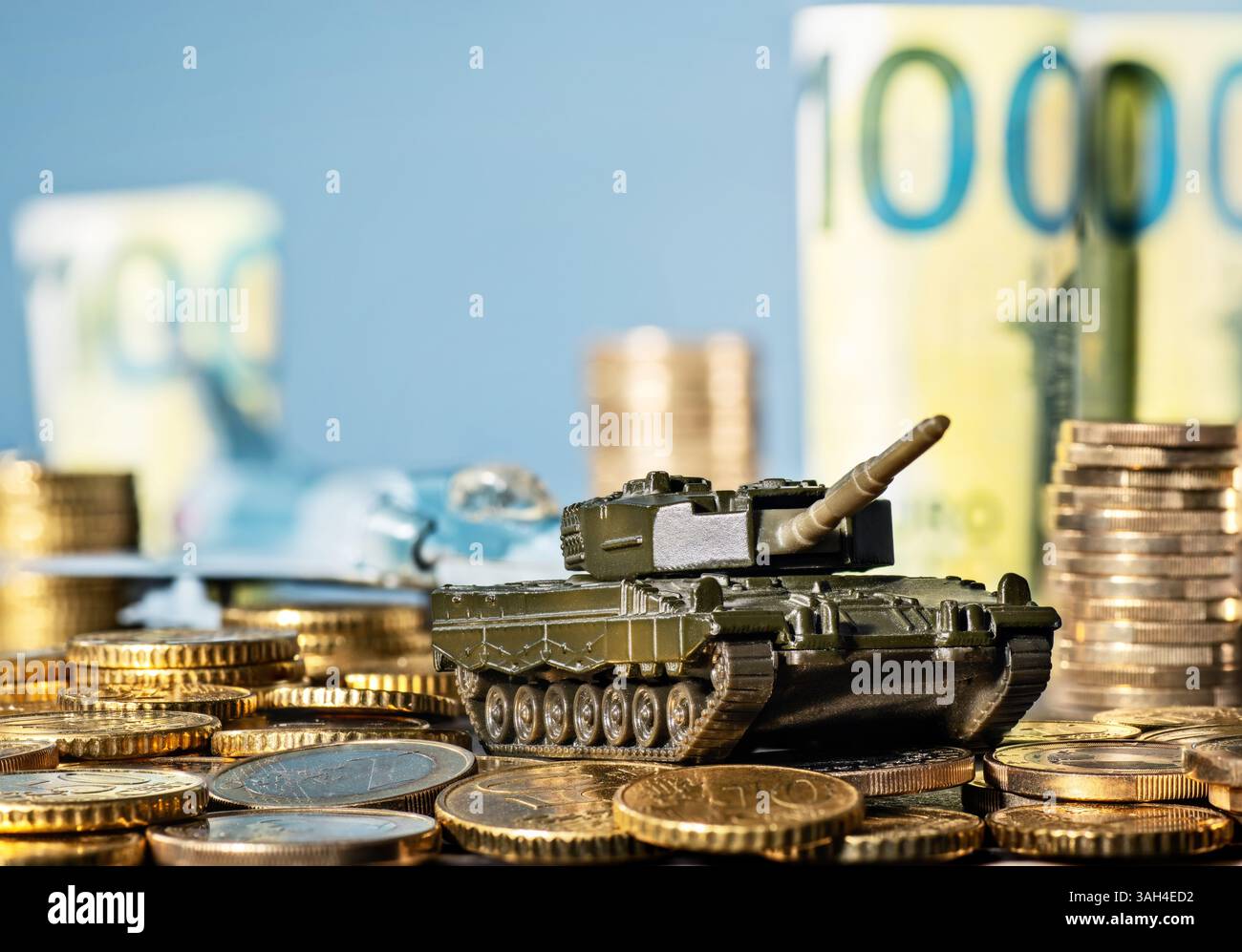 Panzer und Kampfflugzeug mit vielen Münzen und Banknoten Stockfoto