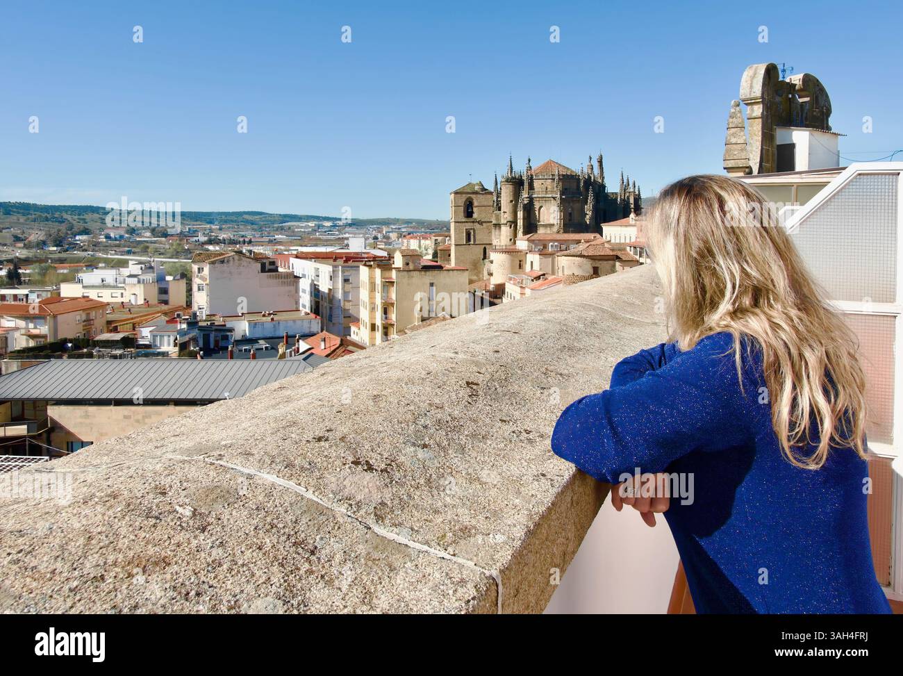 Eine Frau, die von einer Terrasse aus den Blick auf das 4-Sterne-Hotel exe Alfonso VIII mit der neuen und alten Kathedrale Santa Maria Plasencia Spanien Europa schaut Stockfoto