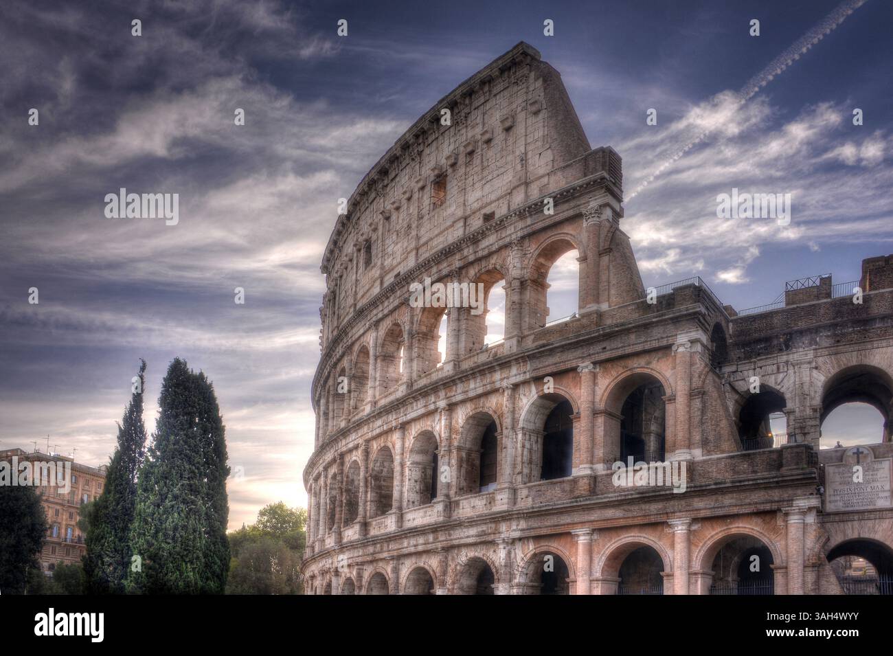 Ein atemberaubender Blick auf das Kolosseum in Rom, Italien, unter einem lebendigen und stimmungsvollen Himmel, mit seinen alten Bögen und seiner zeitlosen Pracht. Stockfoto