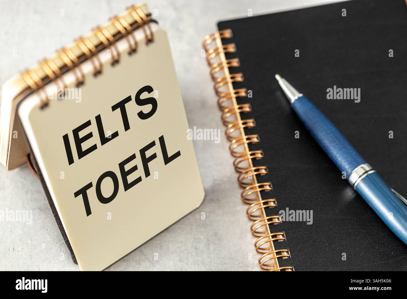 TOEFL und IELTS in Notizbuch geschrieben. Konzeptionelle Wörter. Internationale englischsprachige Tests auf hohem Niveau Stockfoto