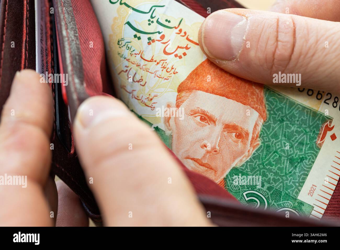 Pakistanische Rupien nehmen aus einer Brieftasche Stockfoto