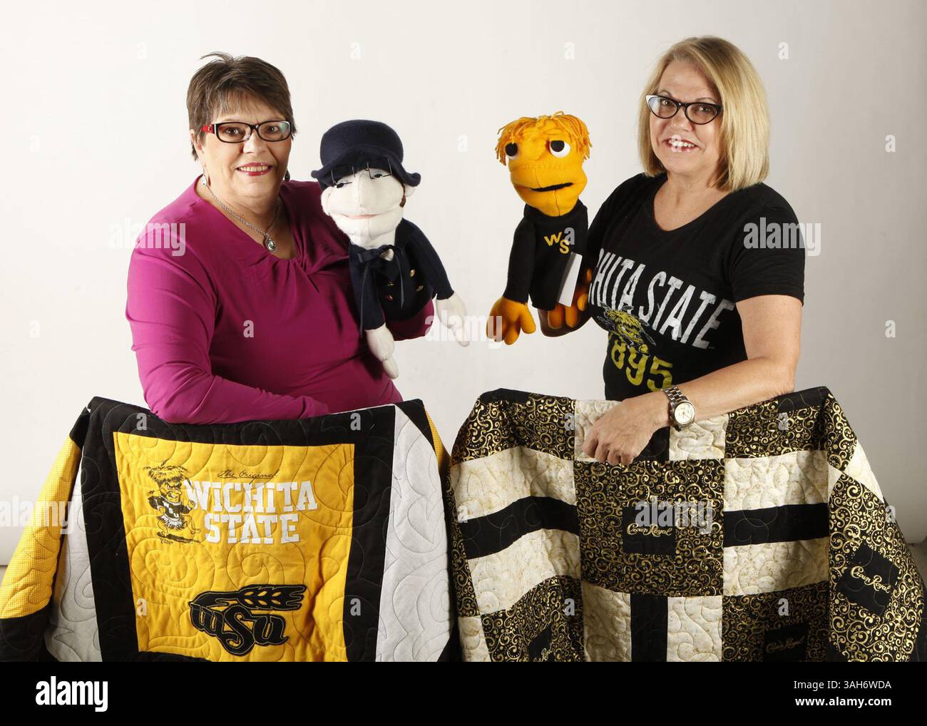 4. März 2015 – Wichita, KS, USA – Patricia Becker, Left, und Mary Brewster posieren mit einigen ihrer Projekte, die sie für ihre Firma Seven and Half Sisters Quilting am 4. März 2015 in Wichita machen. Becker hält eine ihrer Universitätspuppen WeBod für die Washburn Ichabods, während Brewster WeWu für die WSU Shockers hält. Die Quilts, die sie zeigen, sind ein Wichita State Quilt und ein Crown Royal Quilt. (Bild: © Brian Corn/TNS/ZUMA Wire) Stockfoto