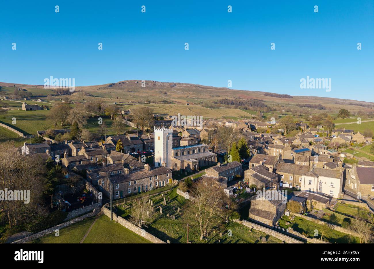 Die Pfarrkirche St. Oswalds in Askrigg, Wensleydale, an einem angenehmen Frühlingsabend, mit ihrem umstrittenen neu renovierten weißen Glockenturm, der Stockfoto