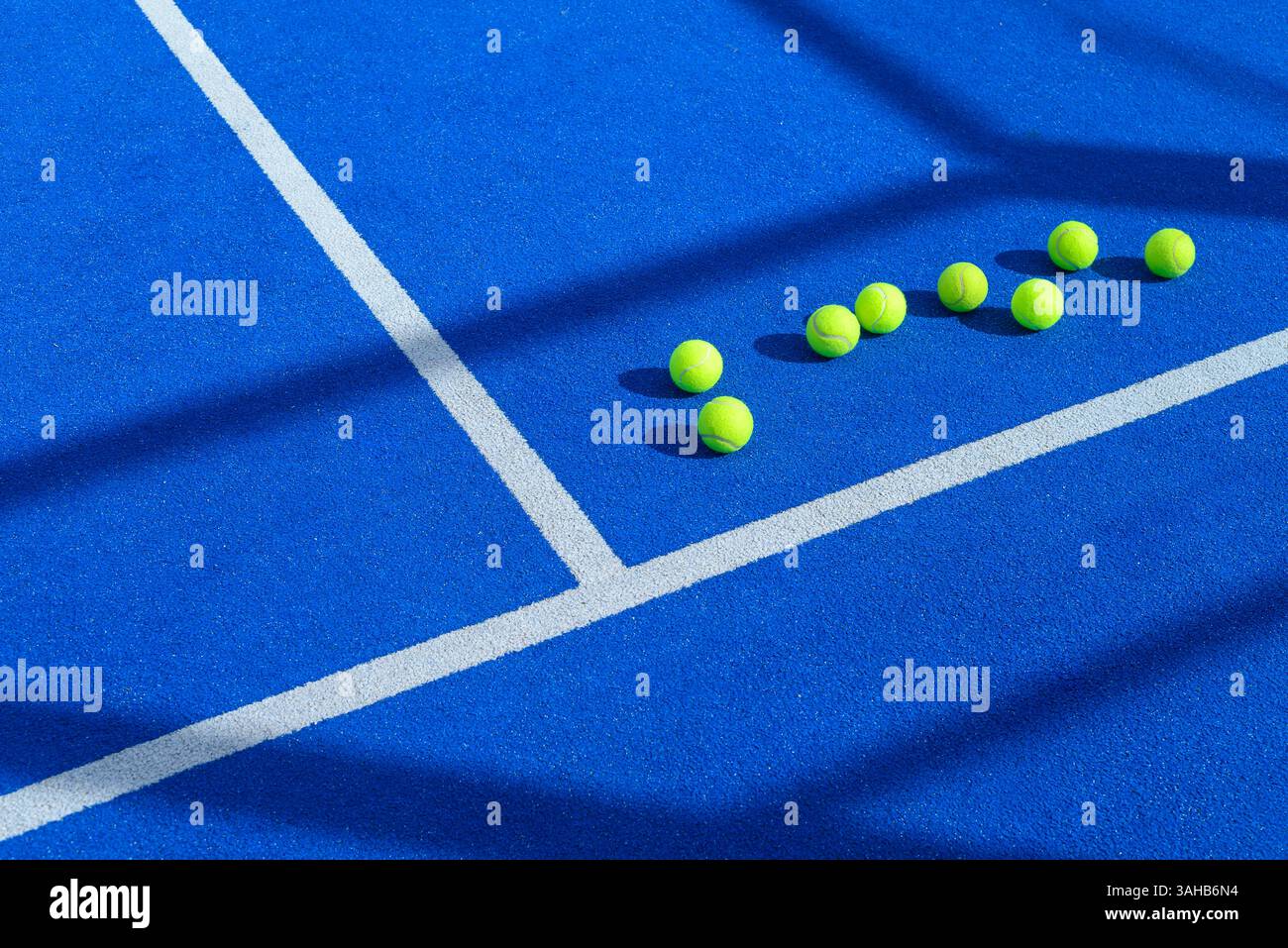 Sieben Bälle auf einem blauen Padel-Tennisplatz, Konzept des Schlägersporthintergrunds Stockfoto