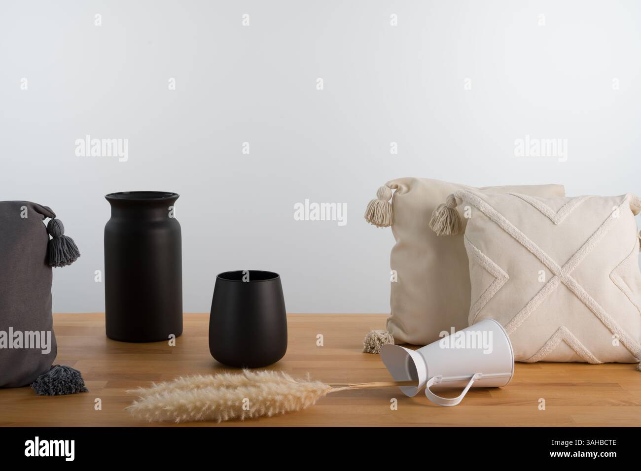 Minimalistische Inneneinrichtung: Schwarze Vasen und strukturierte Kissen zum Stillleben Stockfoto