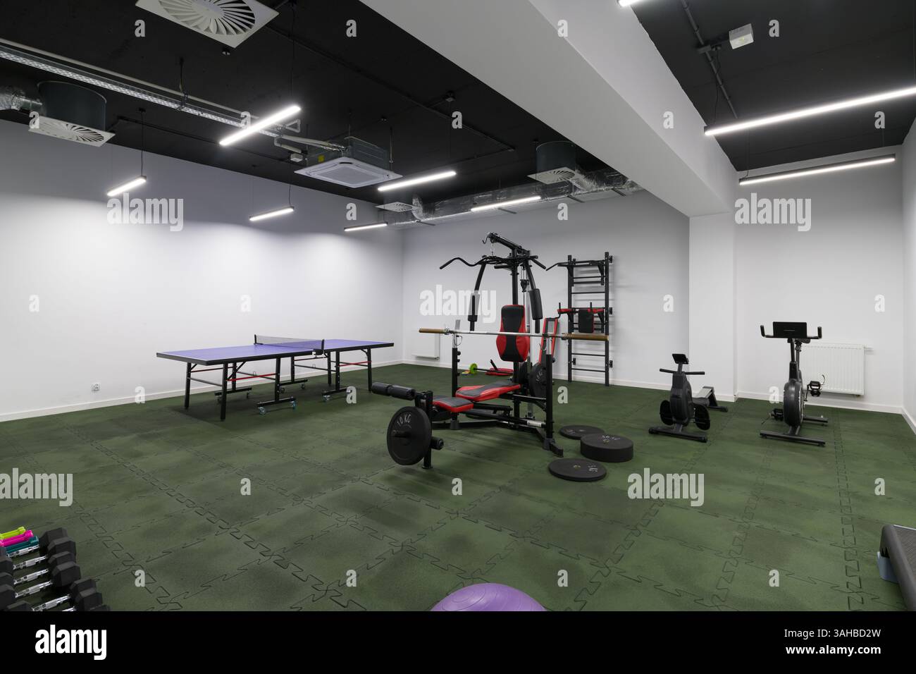Fitnessraum mit Tischtennis und Fitnessgeräten Stockfoto