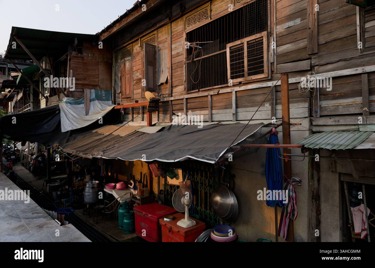 Traditionelle Holzhäuser mit Straßenküchen in Bangkoks älteren Vierteln Stockfoto