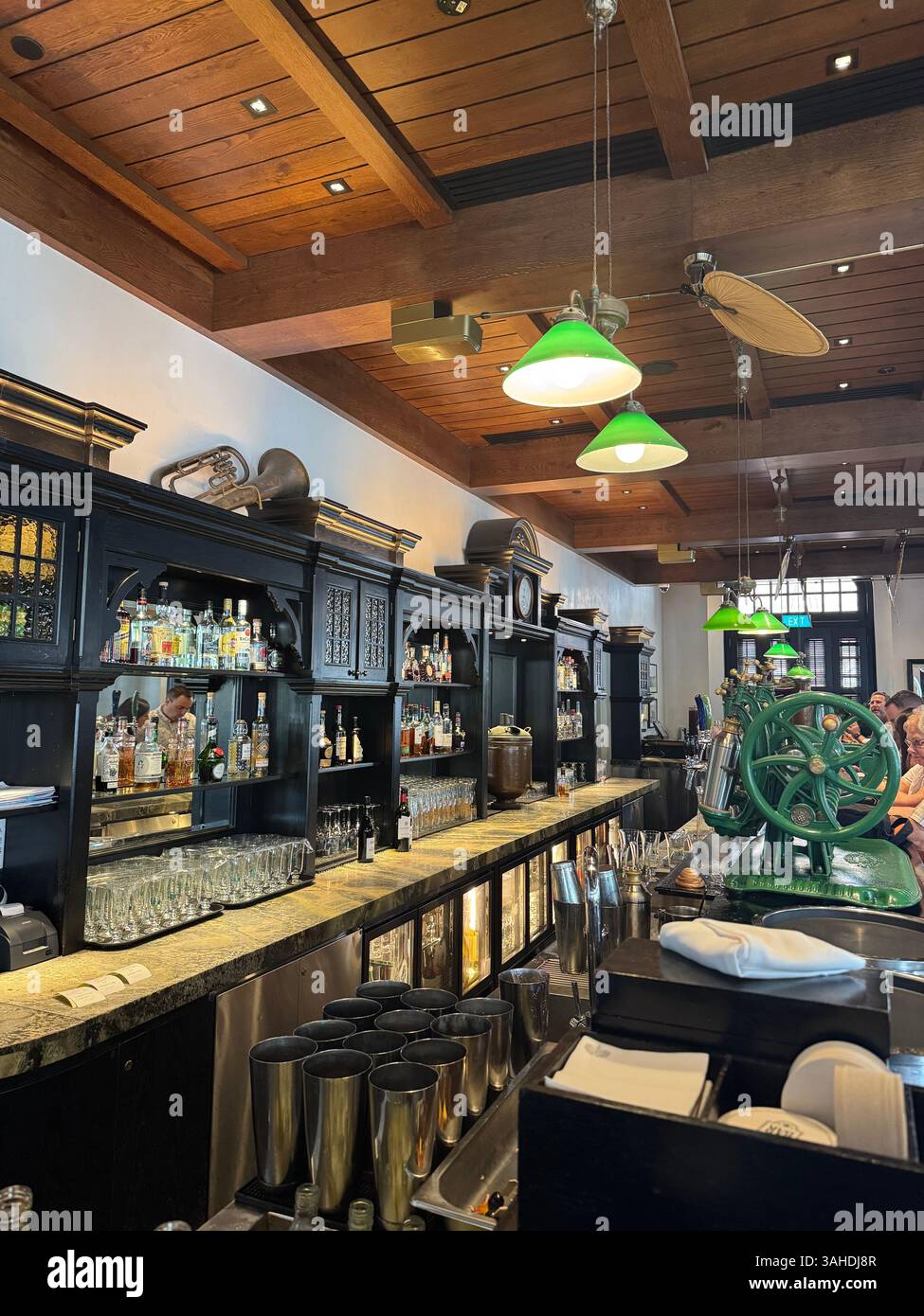 Die historische Long Bar im Raffles Hotel, Singapur – Heimat des Singapore Sling und zeitloser kolonialer Charme. - Smartphone-aufgenommenes Stockfoto