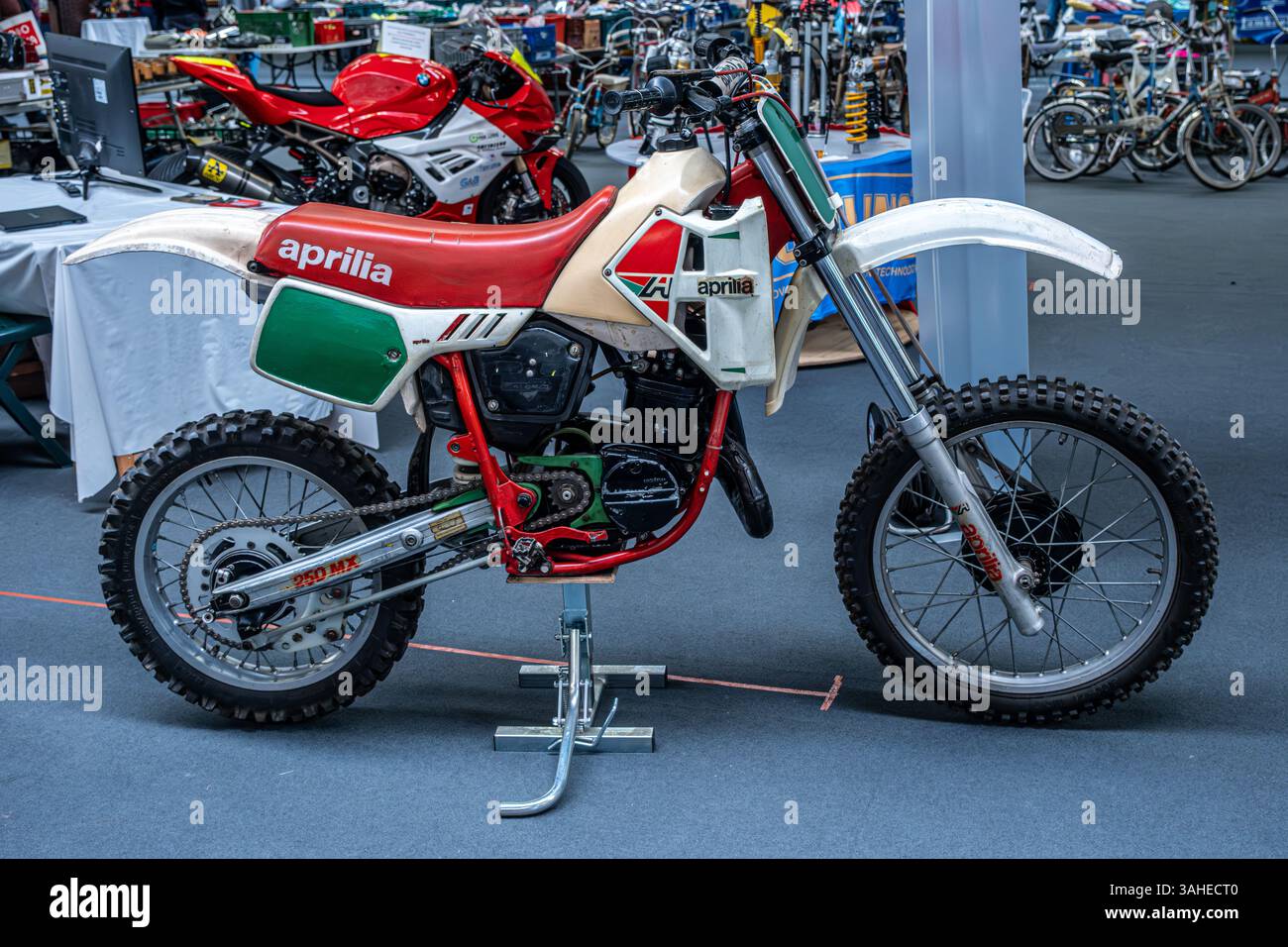 Modena, Italien : 2025 03 30 Motor fest Expo Motorrad Ein klassisches weißes, rotes und grünes Aprilia MX 125 Motocross Motorrad wird in Innenräumen ausgestellt. Hochwertige Fotos Stockfoto