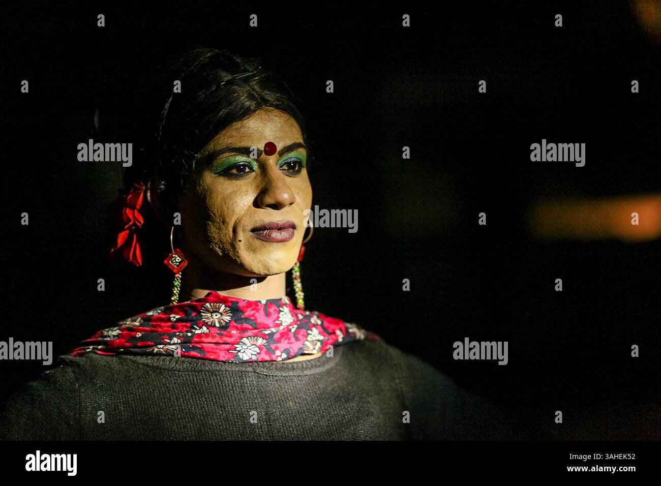 Kühnes nächtliches Porträt eines Transgender-Künstlers in traditionellem Make-up und Schmuck, das Stärke, Identität und Widerstandsfähigkeit in Südasien symbolisiert. Stockfoto