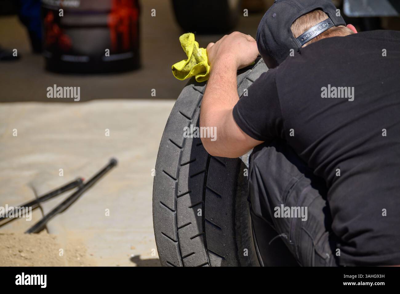 Mechaniker-Handreinigung verschmutzte Radlaufreifen Detailansicht Wartung Details Stockfoto