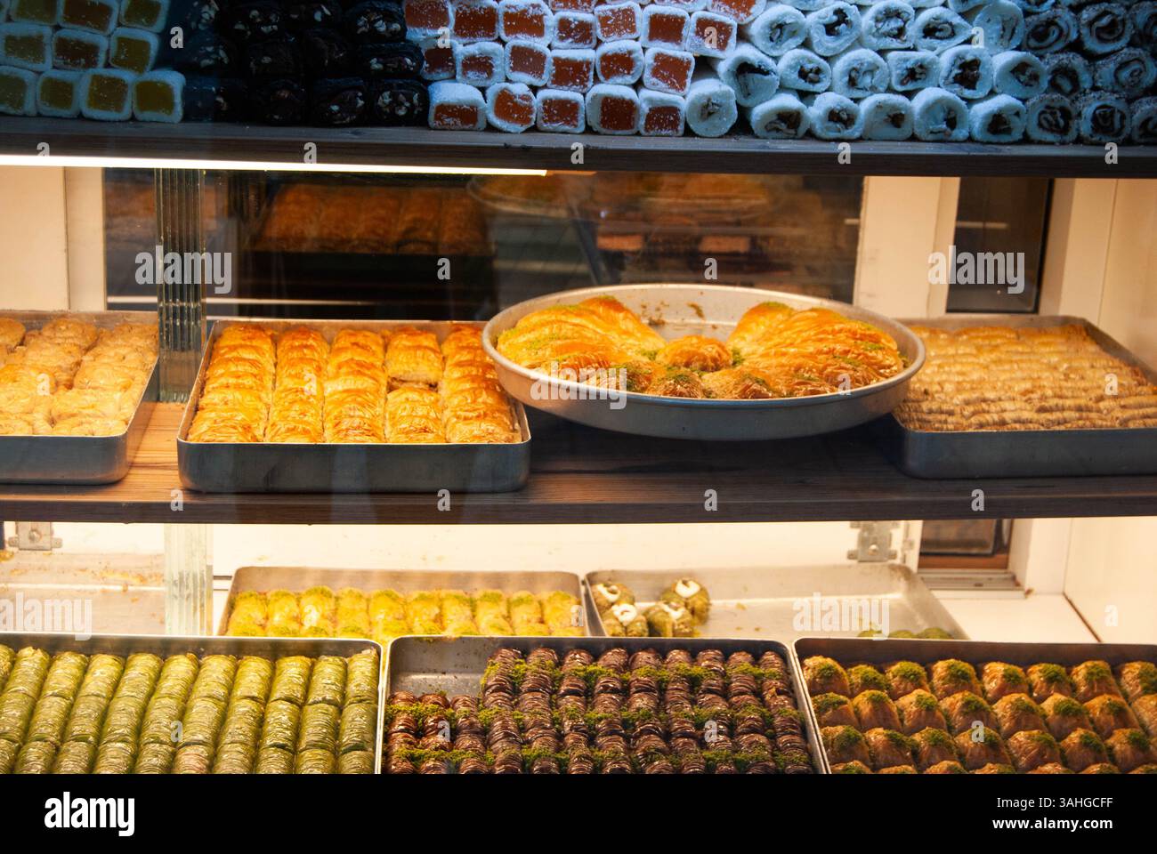 Buntes Baklava-Schaufenster gefüllt mit goldenen, sirupartigen Backwaren. Stockfoto