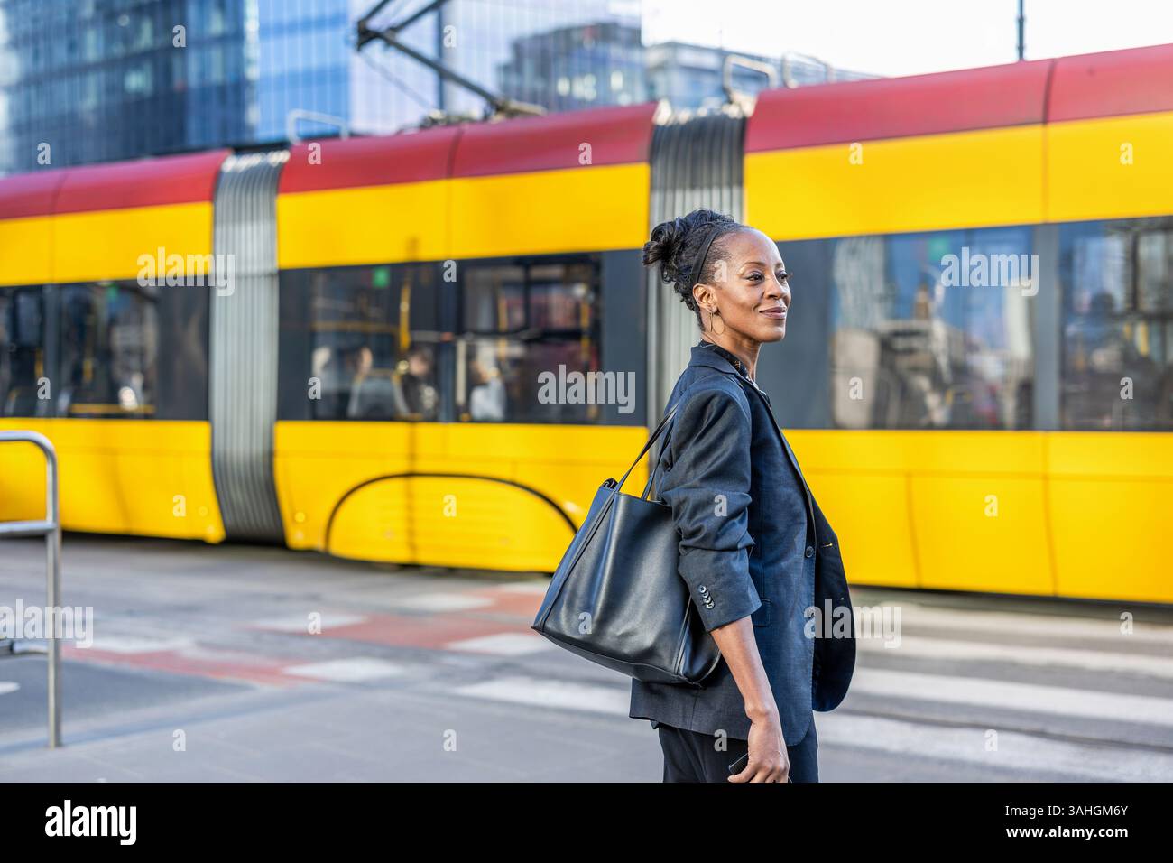 Glückliche Geschäftsfrau mit öffentlichen Verkehrsmitteln in der Stadt Stockfoto