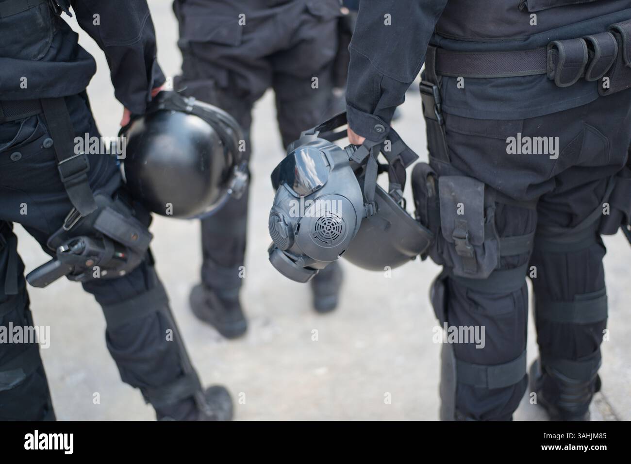 Drei Offiziere in taktischer Ausrüstung halten Helme in einer städtischen Umgebung. Mexiko-Stadt, Mexiko Stockfoto