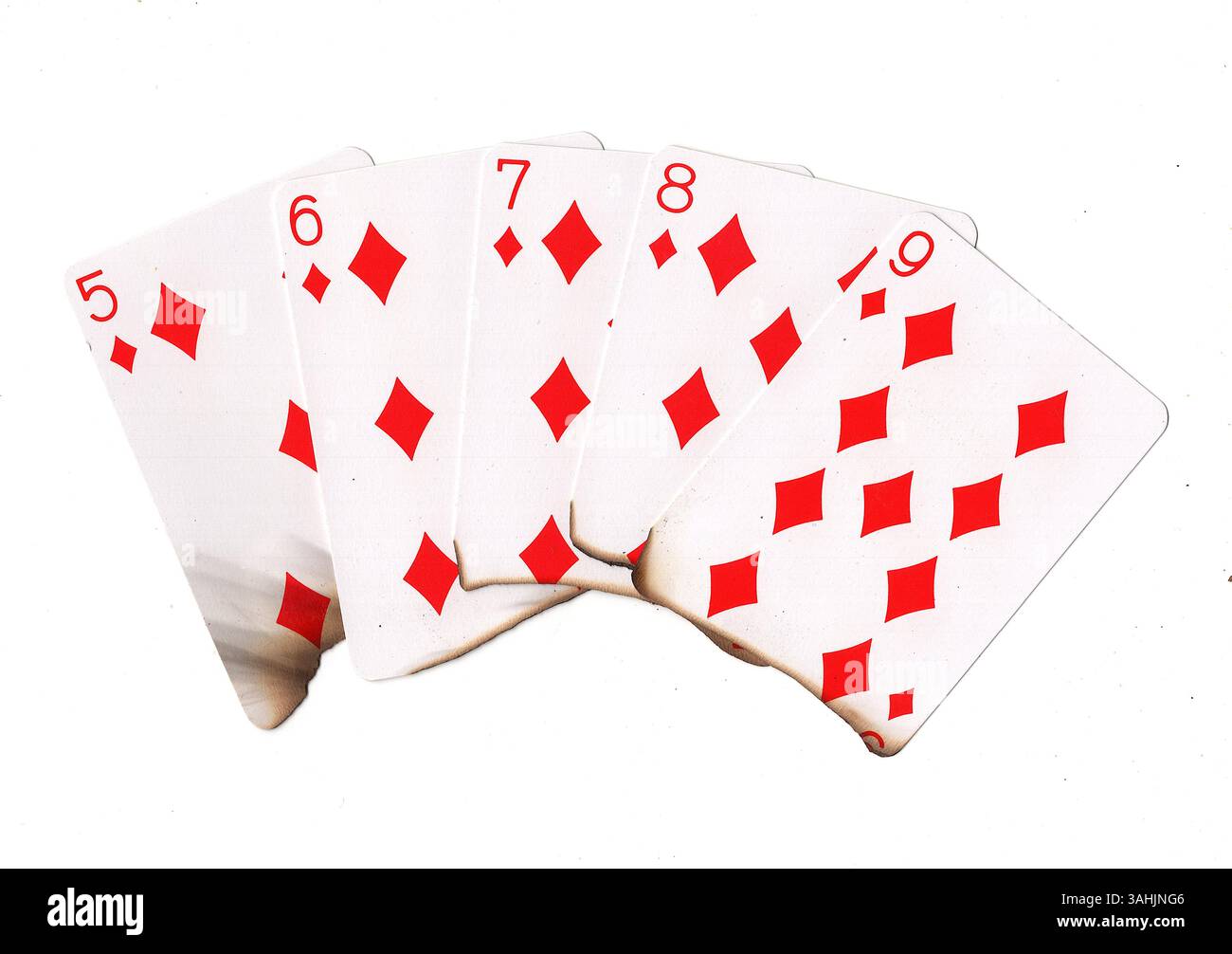 Eine Hand aus teilweise verbrannten Spielkarten in Diamanten auf weißem Hintergrund. Stockfoto