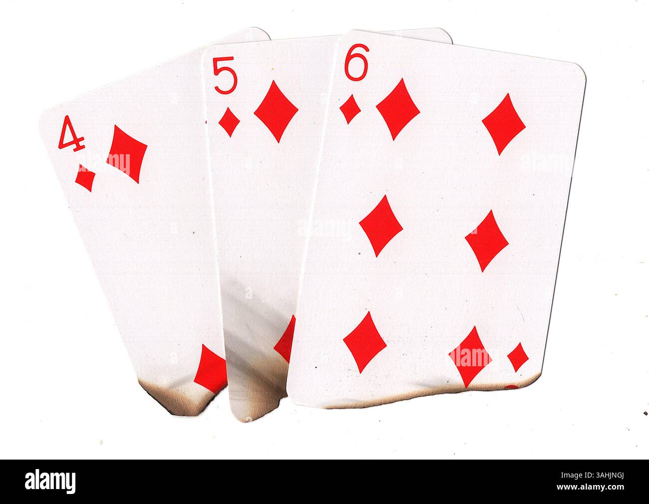 Eine Hand aus teilweise verbrannten Spielkarten in Diamanten auf weißem Hintergrund. Stockfoto