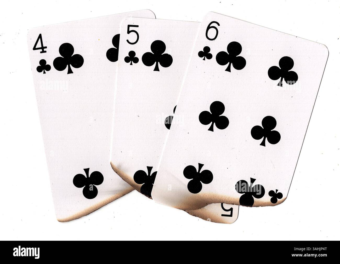Eine Hand aus teilweise verbrannten Spielkarten in Schlägern auf weißem Hintergrund. Stockfoto