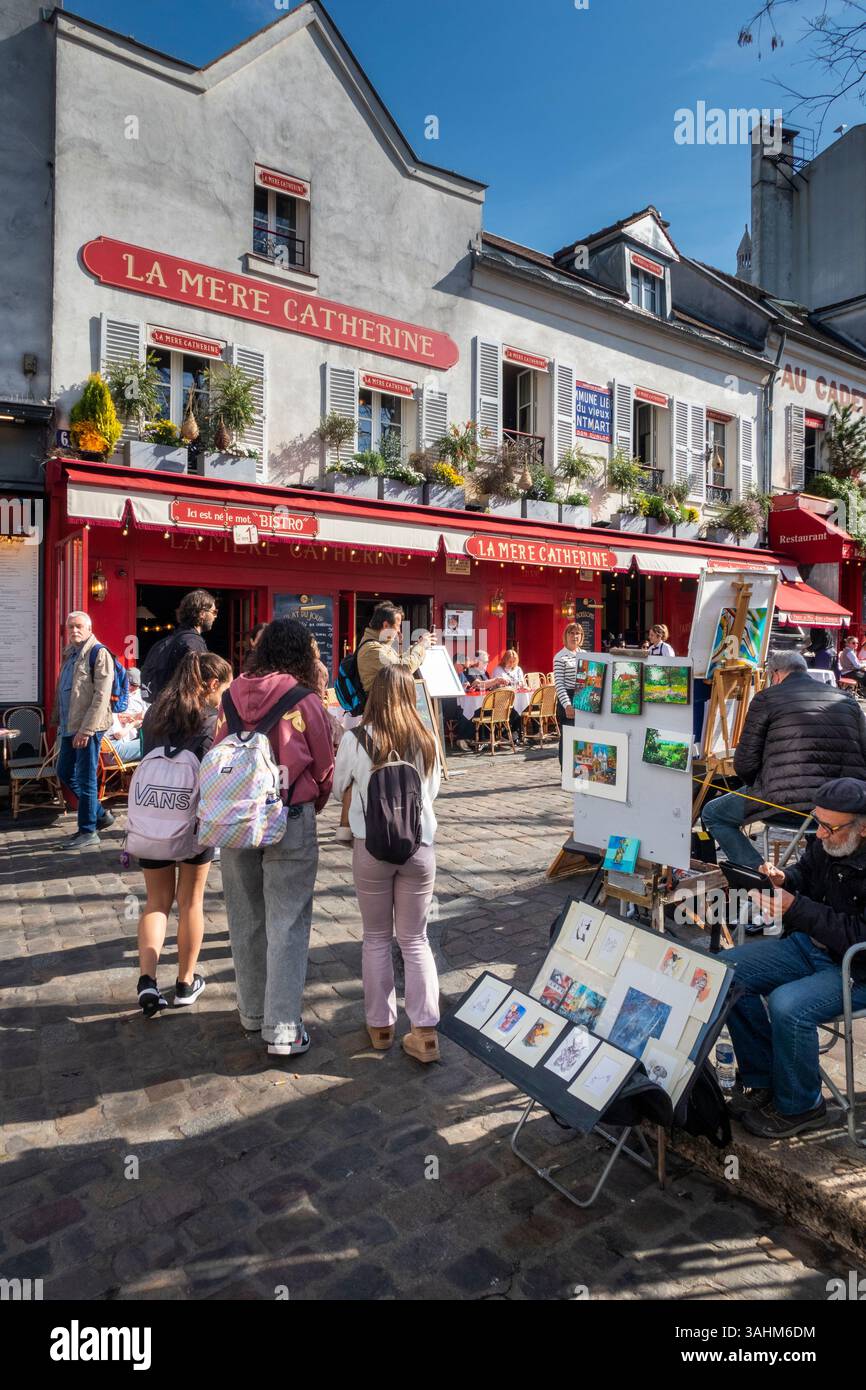 Frankreich, Paris, Montmartre, Place du Tertre, Künstler, der Arbeiten auf dem Bürgersteig gegenüber dem Restaurant La Mere Catherine zeigt Stockfoto